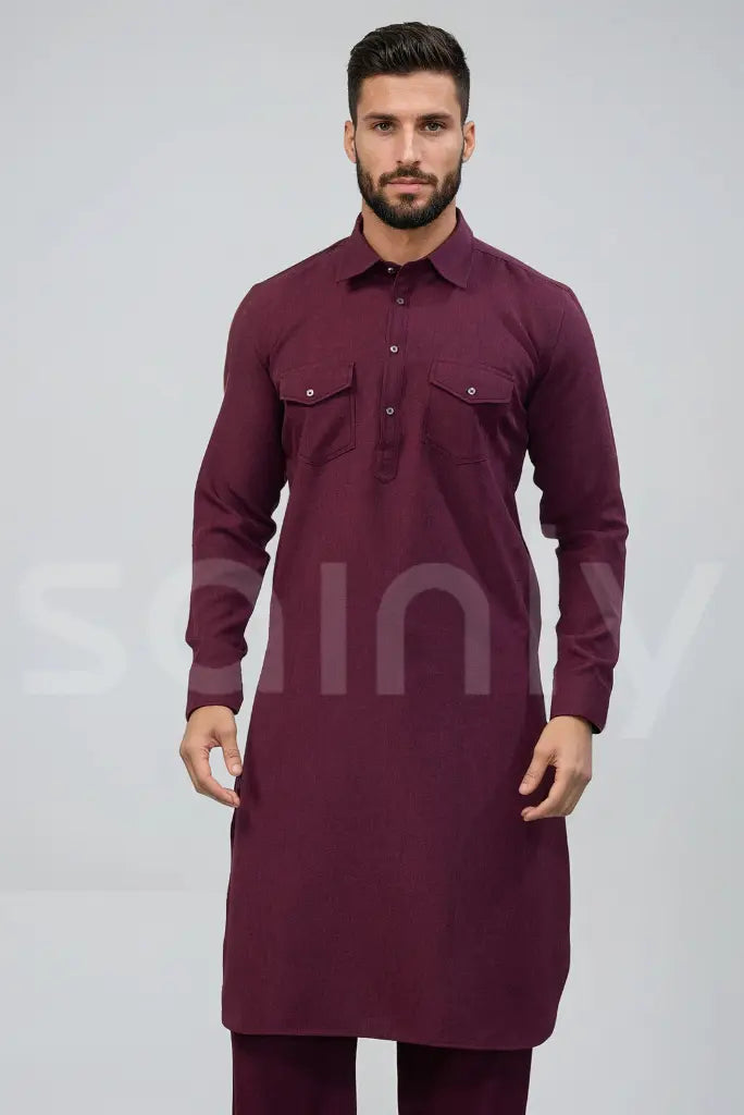 Front view of a custom-fit men's Burgundy Pathani suit set with cuffed roll-up sleeves and matching loose salwar trousers in stretchable fabric.